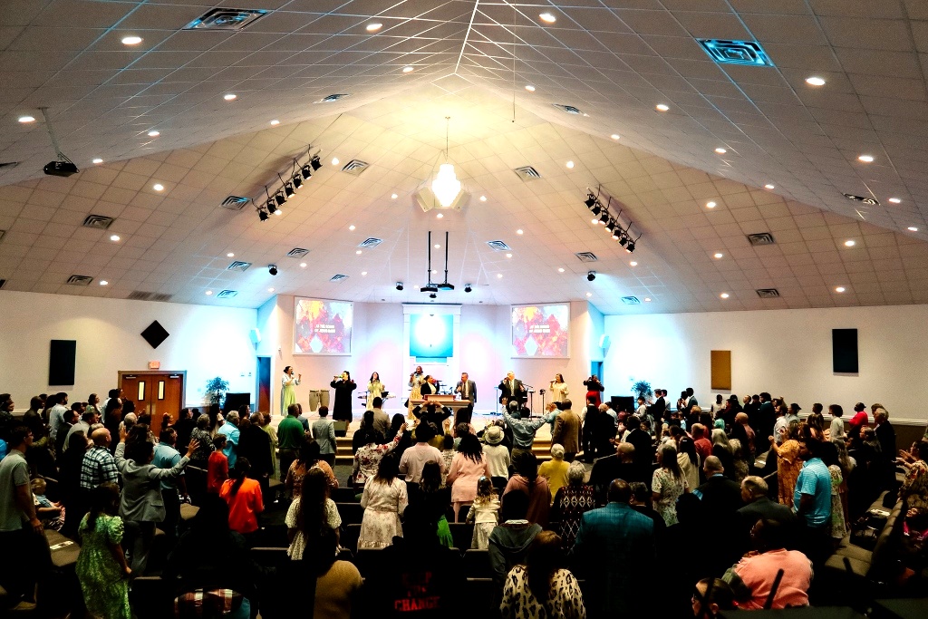 The Sanctuary congregation standing and worshiping inside the sanctuary during a service